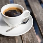 Kupillinen mustaa kahvia terassipöydällä.