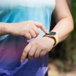 Nainen katsoo ranteessaan olevaa urheilukelloa.