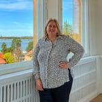 Kiinteistönvälittäjä Manna Satuli seisoo arvokkaan asunnon erkkerissä merennäköalalla Helsingissä
