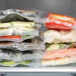 Pakastimen hylly täynnä vakuumiin pakattuja kasviksia ja kalaa