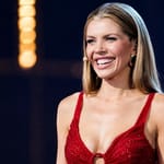 Victoria Swarovski hymyilee punaisessa iltapuvussa Euroviisujen lavalla