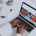 Matkailija selaa Airbnb-ilmoituksia kannettavalla tietokoneella — Airbnb-arvostelujen varoitusmerkit jäävät usein huomaamatta