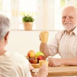 Meemistä tunnettu harmaatukkainen mies, Hide the Pain Harold, istuu keittiön pöydän ääressä pidellen keltaista mukia ja hymyilee vaivaantuneesti naisen suuntaan.