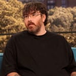 Michael Phillips istuu televisio-ohjelman sohvalla mustat lasit päässä