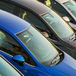 Rivi erivärisiä ja siistikuntoisia käytettyjä henkilöautoja pysäköitynä vierekkäin.
