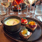 Ravintola Skördun maistelulautanen, taustalla viinilaseja.