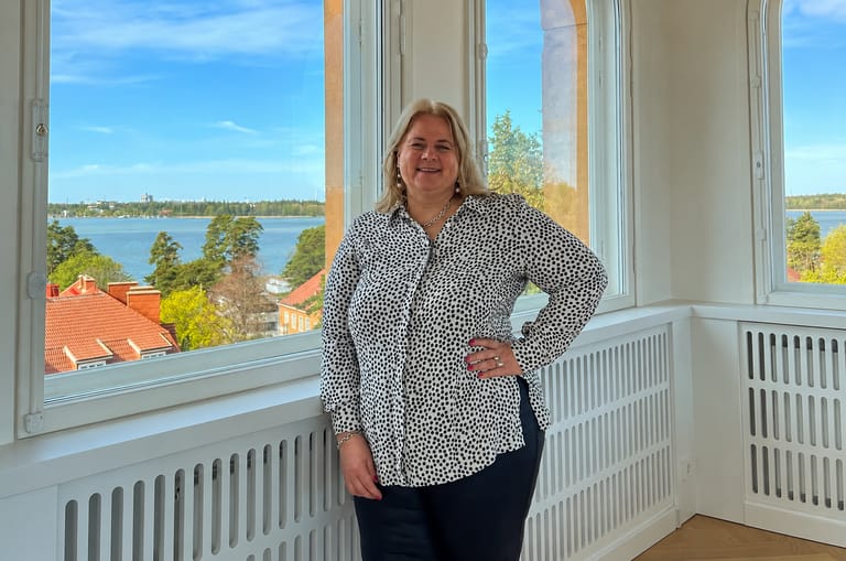 Kiinteistönvälittäjä Manna Satuli seisoo arvokkaan asunnon erkkerissä merennäköalalla Helsingissä