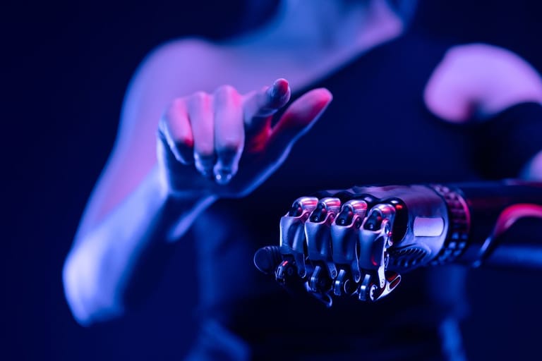 Kuvassa on violettisävyisenä nainen, jolla on robottikäsi. Se on kuvaannollinen kuvituskuva AI-ta käsittelevälle artikkelille.