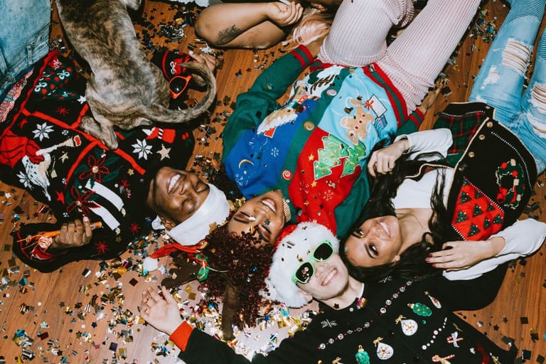 Nuoriso joulutunnelmissa kaiken serpentiinin keskellä tonttulakit päässä. Kuvituskuva artikkelille joka käsittelee GEN Z joulunviettoa.