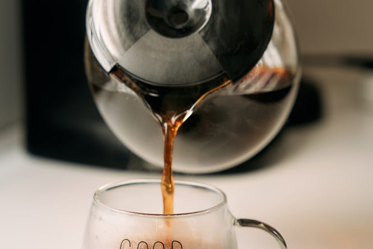 Kahvia kaadetaan läpinäkyvään mukiin kahvipannusta.