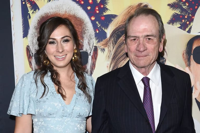 Tommy Lee Jones poseeraa yhdessä tyttärensä Victoria Jonesin kanssa elokuvan ensi-illassa. Nainen hymyilee vaaleansinisessä mekossa, ja vieressä seisoo isä tummassa puvussa ja solmiossa. Taustalla näkyy värikäs elokuvajuliste.