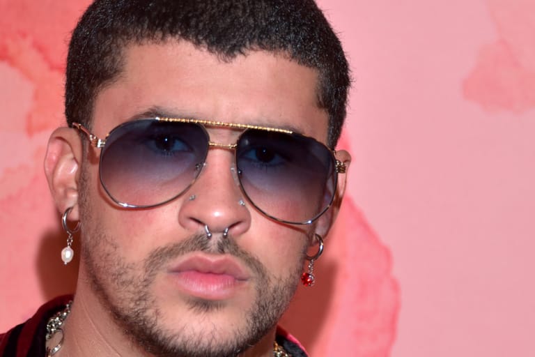 Bad Bunny artisti vaaleanpunaisella taustalla, aurinkolasit päässä