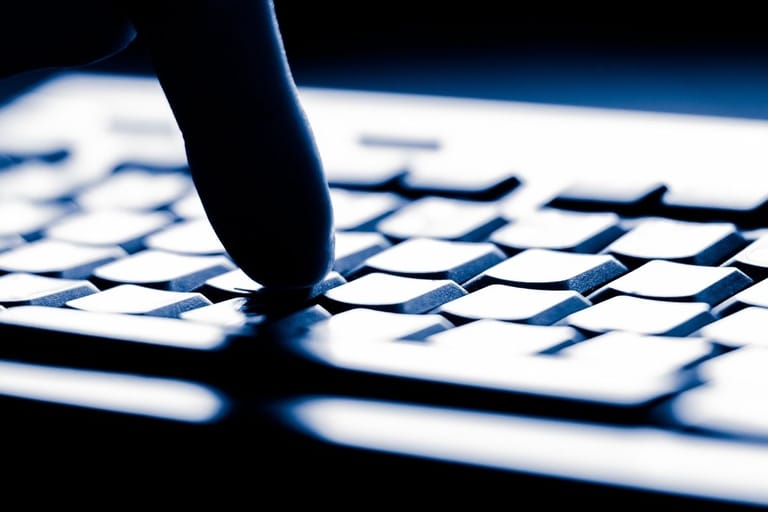 Sormi painaa näppäimistöä pimeässä – CSAM-ilmiö liittyy verkossa tapahtuvaan rikolliseen toimintaan