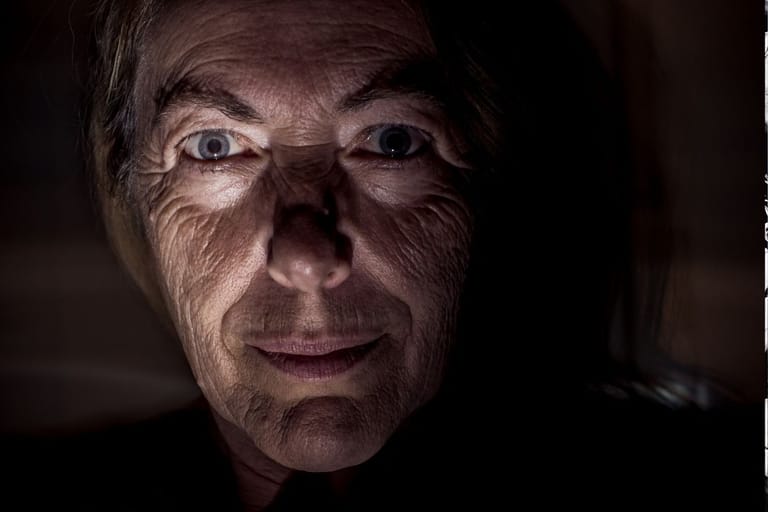 Henkilön intensiivinen katse pimeässä – psykopaatin piirteet ja tunteiden tulkinta