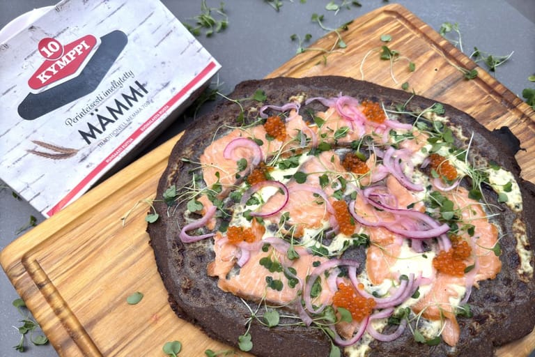 Mämmistä valmistettu tumma pizza, vieressä paketti mämmiä.