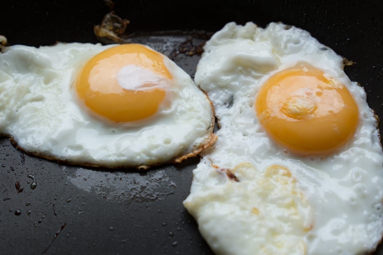 Kaksi paistettua kananmunaa pannulla.