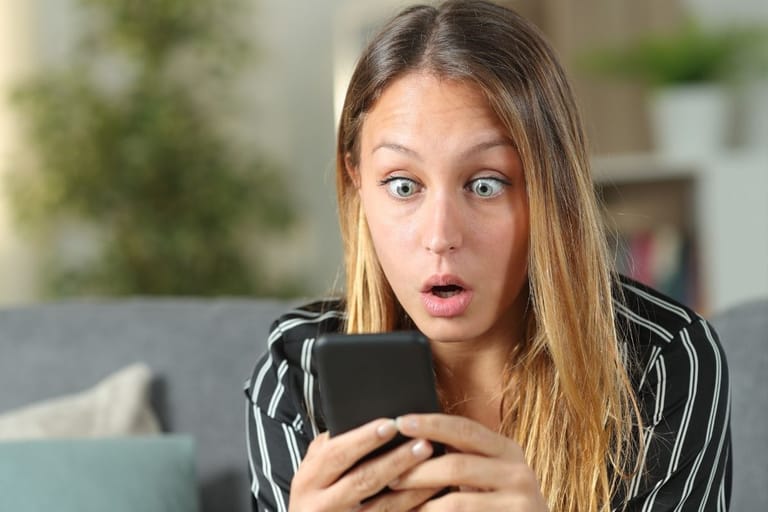 yllättynyt nainen katsoo puhelinta kohdennettu mainonta algoritmi seuraa käyttäytymistä