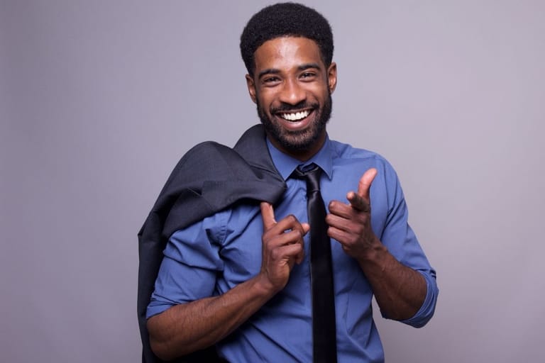hymyilevä mies osoittaa kameraan itsevarma ilme huumorintaju persoonallisuus