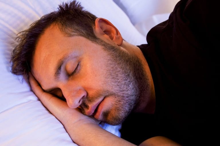 mies nukkuu sängyssä rauhallisesti – eri nukkujatyyppien vaikutus uneen