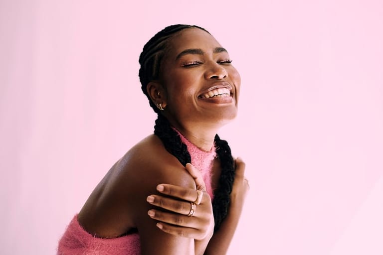 Hymyilevä nainen nauttii hetkestä – itsevarmuus ja läsnäolo lisäävät vetovoimaa