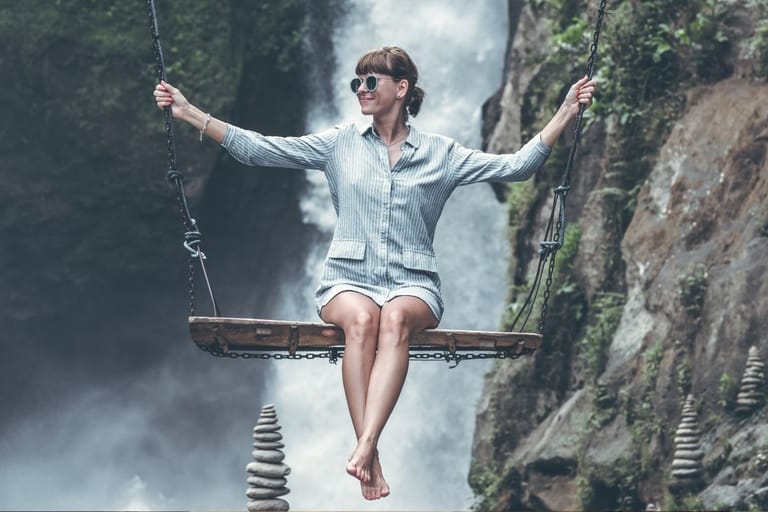 Itsenäinen nainen keinussa luonnossa – sinkkuelämä ja vapaus kuvattuna