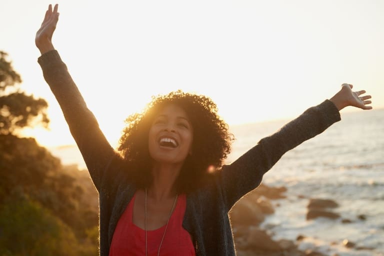 nainen nauttii yllättävästä vapaa-ajasta auringonlaskussa rannalla