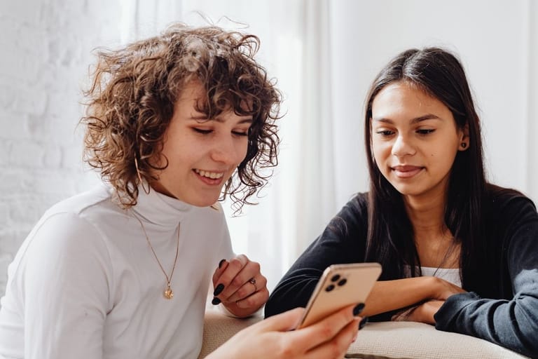 ystävät katsovat puhelinta yhdessä viestintä arki keskustelu sosiaalinen media