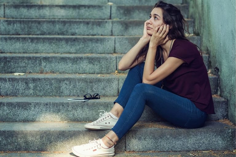 nuori aikuinen yksin portailla – ei kaveriporukkaa aikuisena ja yksinäisyyden tunne