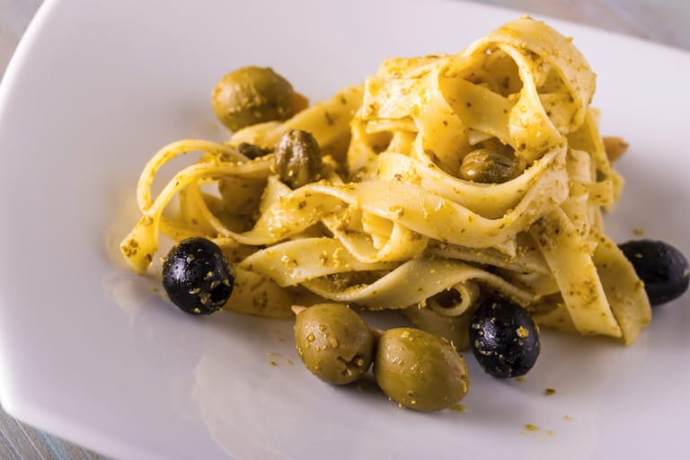 Nauhapastaa, jossa vihreitä ja mustia oliiveja.