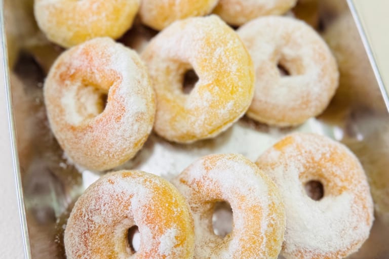 Sokerikuorrutettuja donitseja rivissä.