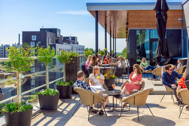 Freja Rooftopin terassi täynnä iloisia ihmisiä.