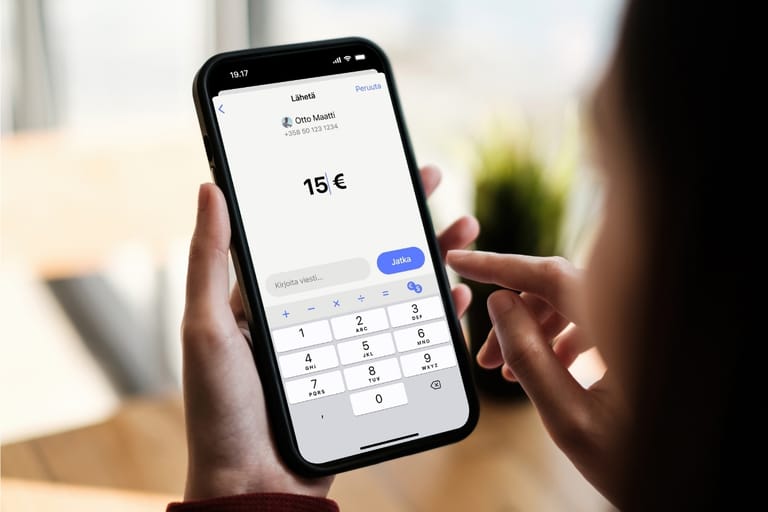 Henkilö lähettämässä 15 euroa MobilePay-sovelluksella älypuhelimella.