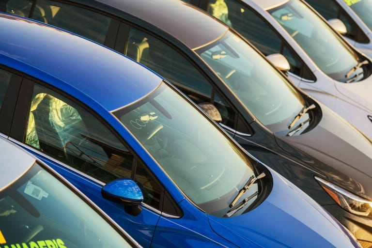 Rivi erivärisiä ja siistikuntoisia käytettyjä henkilöautoja pysäköitynä vierekkäin.