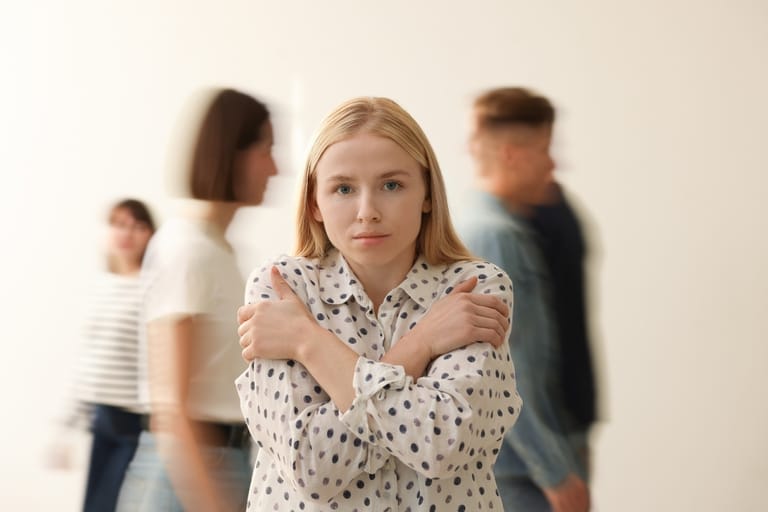Nainen seisoo erillään muista ihmisistä – introverttius ei yksin kerro yksinolon kaipuusta