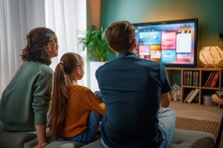 perhe katselee illalla televisiota yhdessä
