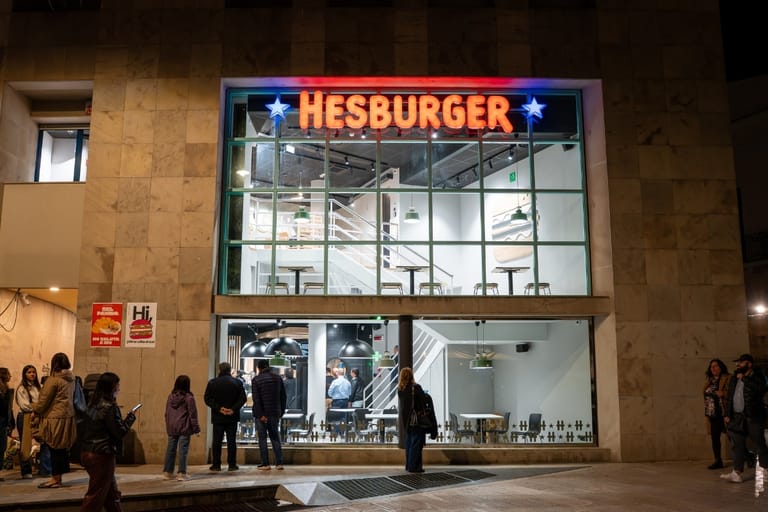 Hesburgerin ensimmäinen ravintola Italiassa, Materan kaupungissa, valaistuna ilta-aikaan ihmisten seistessä sen edustalla.