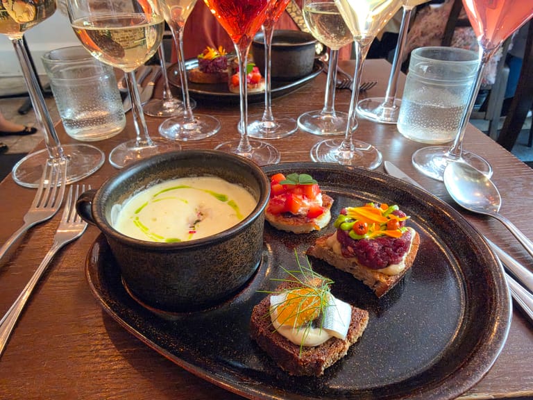 Ravintola Skördun maistelulautanen, taustalla viinilaseja.