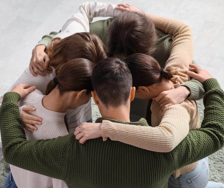 Kuvassa viisi sisarusta on ringissä ryhmähalissa. Sisarukset näkyvät ylhäältäpäin.