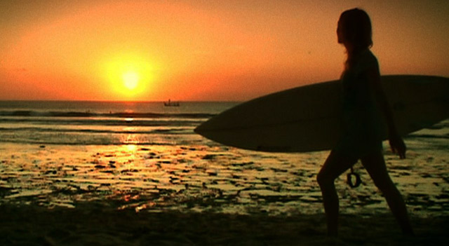 Vaikka Suomessakin saa aaltoja, vetää dokumentin päähenkilöiden veri lämpimien vesien äärelle. Tässä Aija ison meren rannalla.