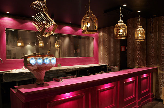 Puumalan pinkit seinät saavat kaverikseen oranssit tuolit ja seepramaton.