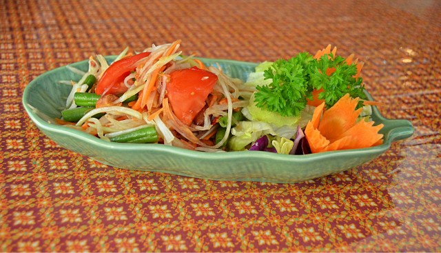 Vihreä suikaloitu papaijasalaatti, chiliä, porkkanoita ja maapähkinöitä. Makuelämys tulisen ruoan ystävälle.