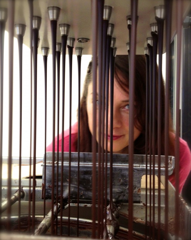 Raakasuklaasuihkussa. Suklaata valutetaan muotteihin etualalla.