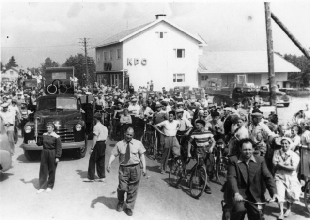 Kuva: Suomen Urheilumuseo CC BY SA Soihtuviesti Himangalla 12.7.1952. Viestiä seuraamaan tullut yleisö täyttää maantien, kuvassa vasemmalla auton edessä soihdunkantaja Anna-Liisa Himanka.