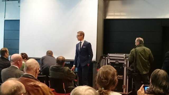 Alexander Stubb pitää vaalitilaisuutta ja samalla TesPack -aurinkoenergialaukun fani nosti tuotesijoittelulla (ilman lupaa??) tuotteen kuviin.