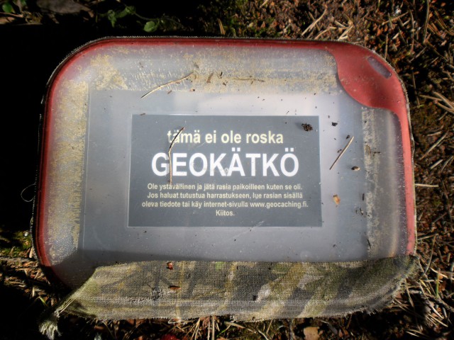 Esimerkki kätköpurkista: vesitiivis rasia tyypillisellä kätkötiedotteella: ei roska, vaan geokätkö.