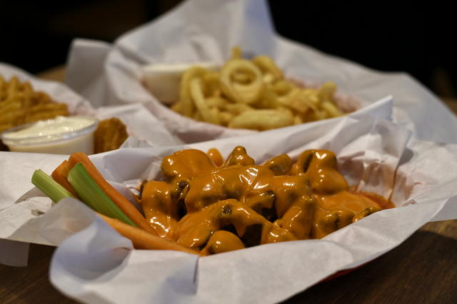 Vegaaninen siiwegeannos pitää sisällään seitanista valmistettuja siiweggeitä, Siipiweikkojen kastiketta sekä porkkana- ja selleritikkuja.