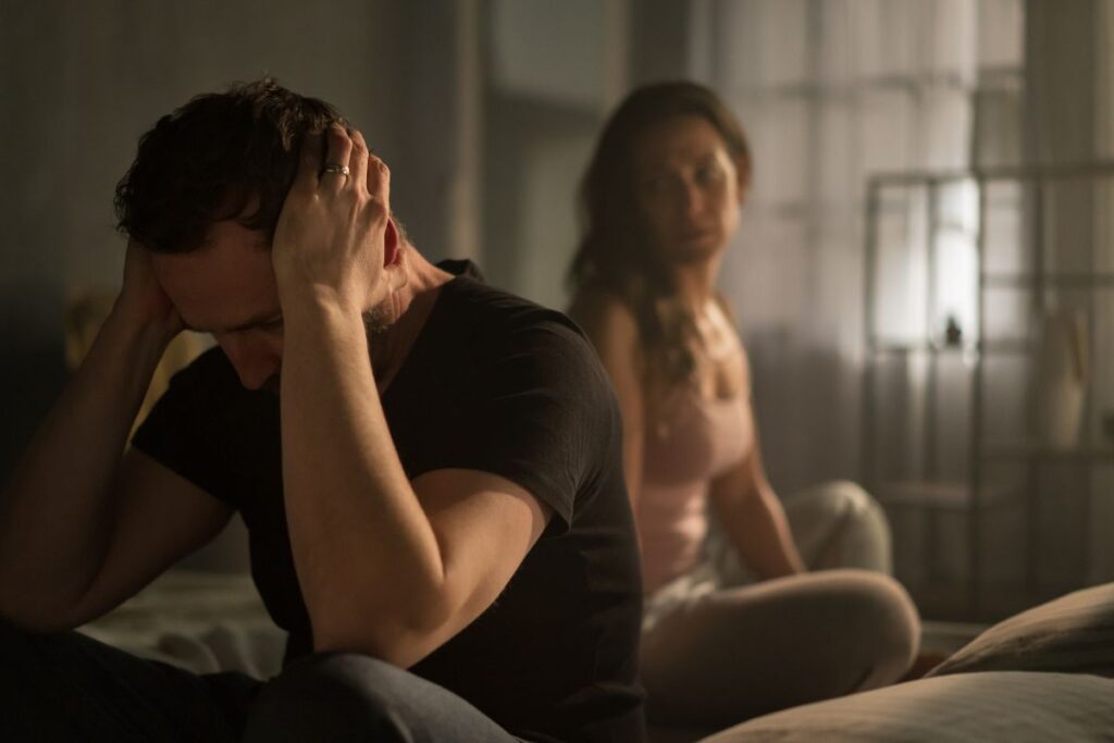 Nainen ja mies riitelee makuuhuoneessa.