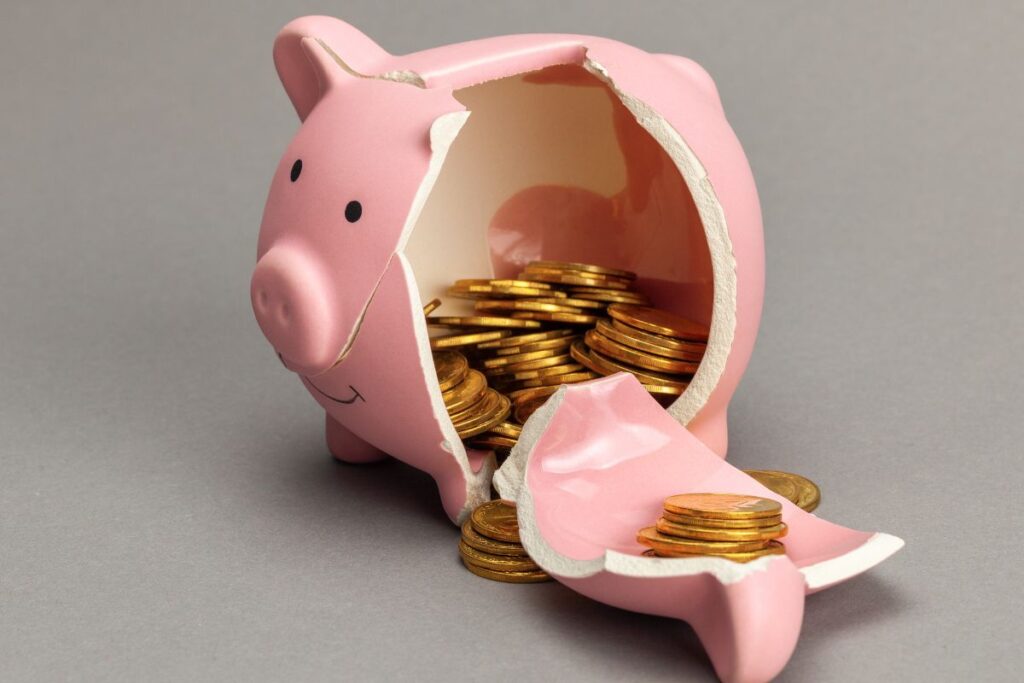 Vaaleanpunainen säästöpossu on rikottu kyljestään ja toimii kuvaannollisena kuvituskuvana taloudelliselle väkivallalle.