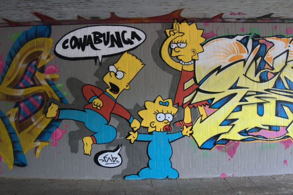 Saksalaista katutaidetta ja graffitteja jossa kuvattuna simpsoneiden perheestä Bart, Lisa ja Maggie-vauva. Spraymaalaus. 