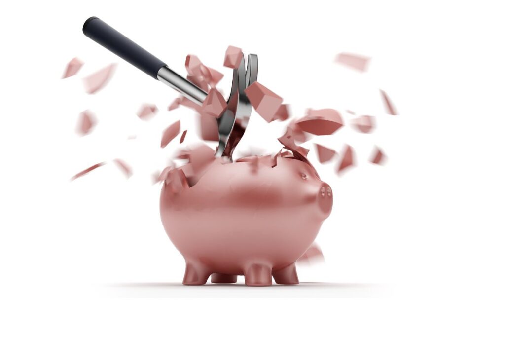 Säästöpossu rikotaan vasaralla ja palat lentelevät.